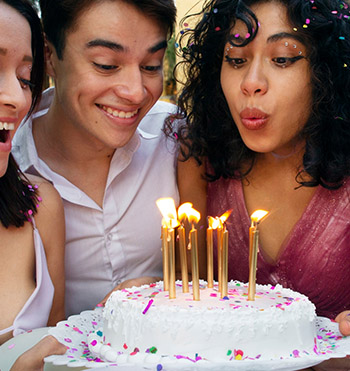  women holding bday cake